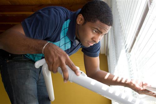 Student Jean Rene Faustin cleaning inside a house.