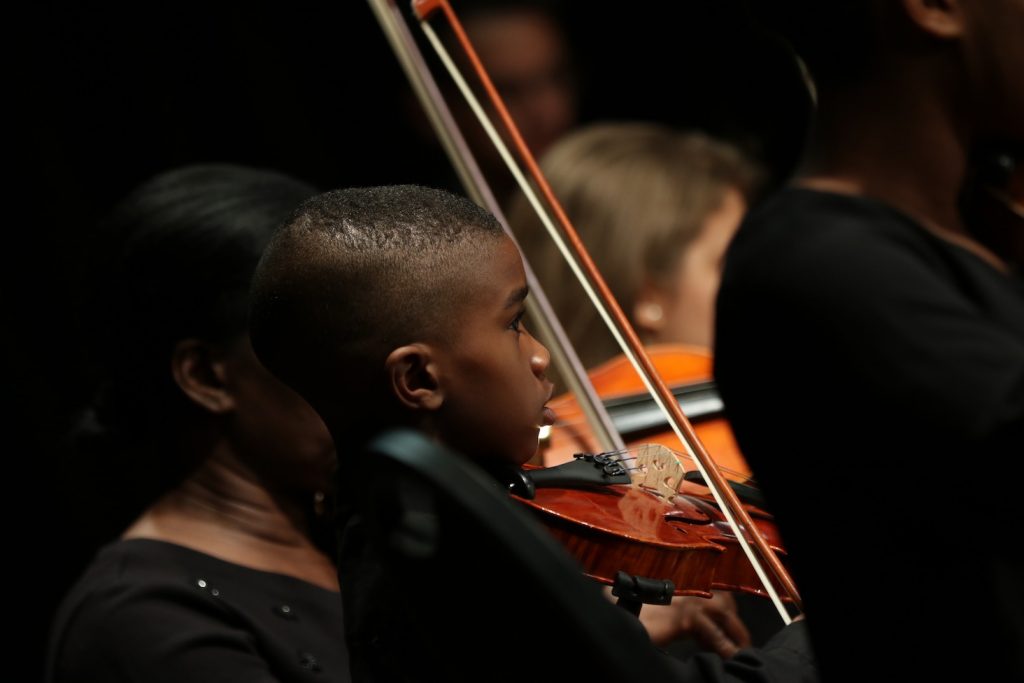 A young boy playing his violin.