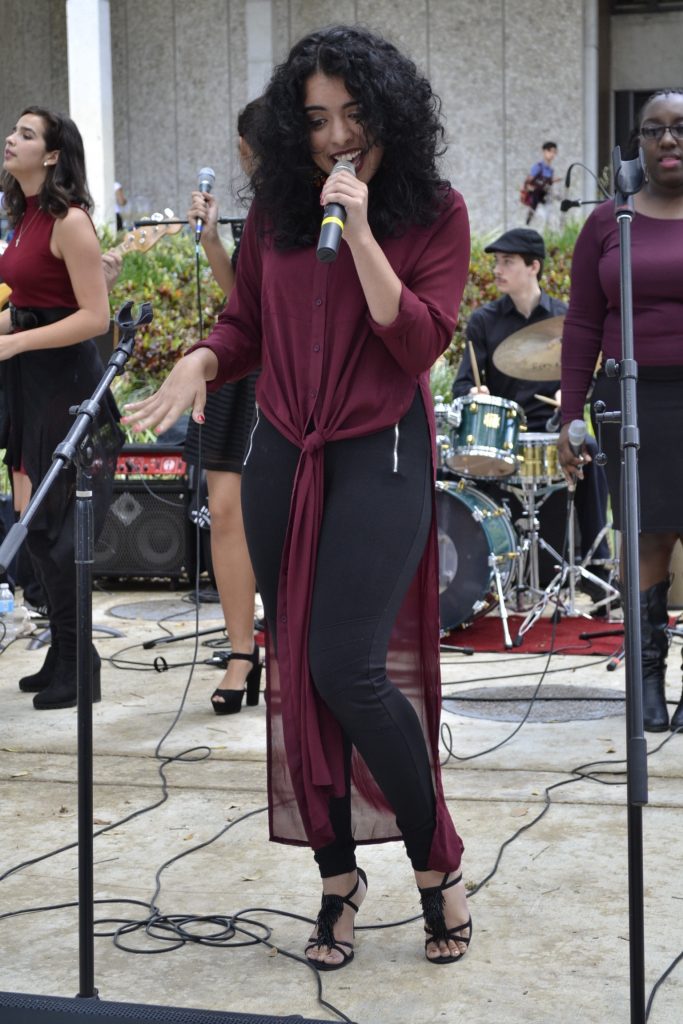 Student performing in front of Koffee House at Kendall Campus.