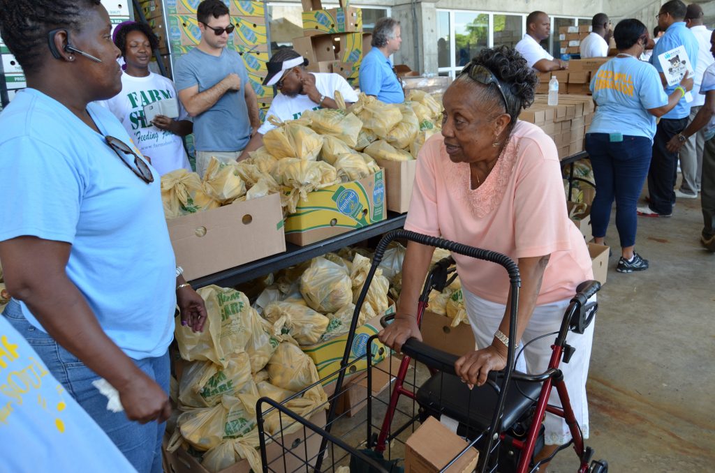 An elderly woman receiving food through the "Back To School" Food Distribution Event.