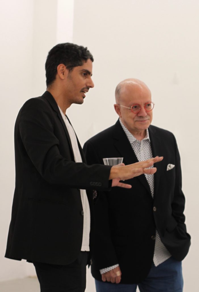 College President Eduardo J. Padrón listening to Leyden Rodriguez-Casanova talking during an art gallery event.
