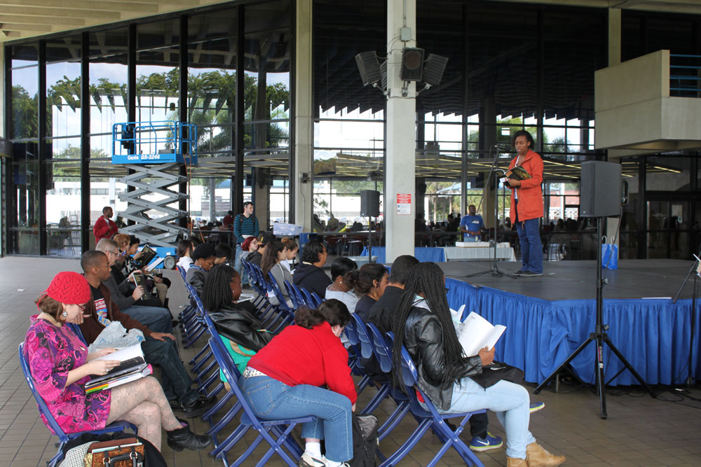 Kathyln reading a poem on stage.