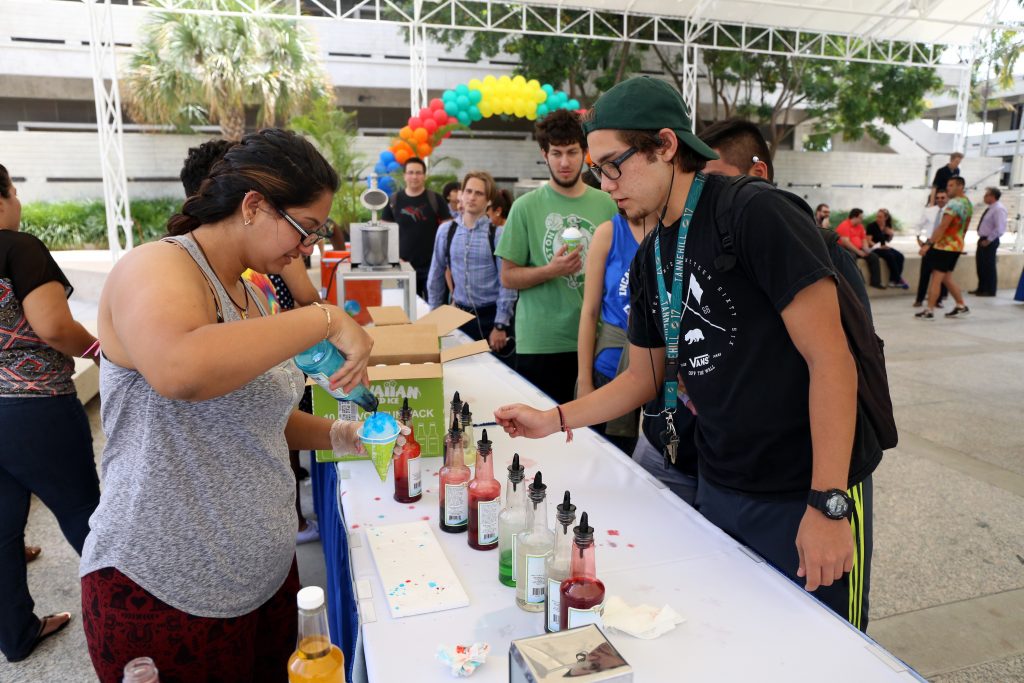 Student serving others snow cones.