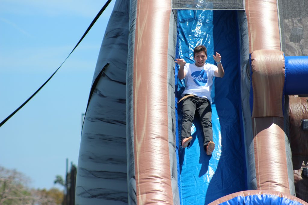 Student sliding down a two-story inflated slide.