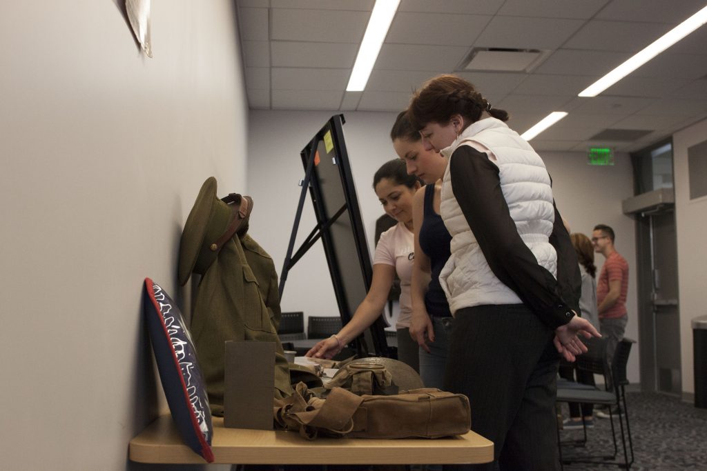 Students looking at artifacts from the American Civil War, World War I and II and the Korean War.