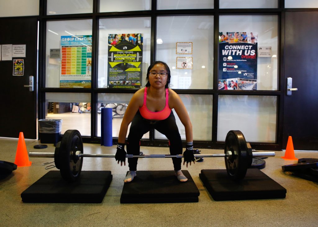 Student Tianmei Ren lifting weights.