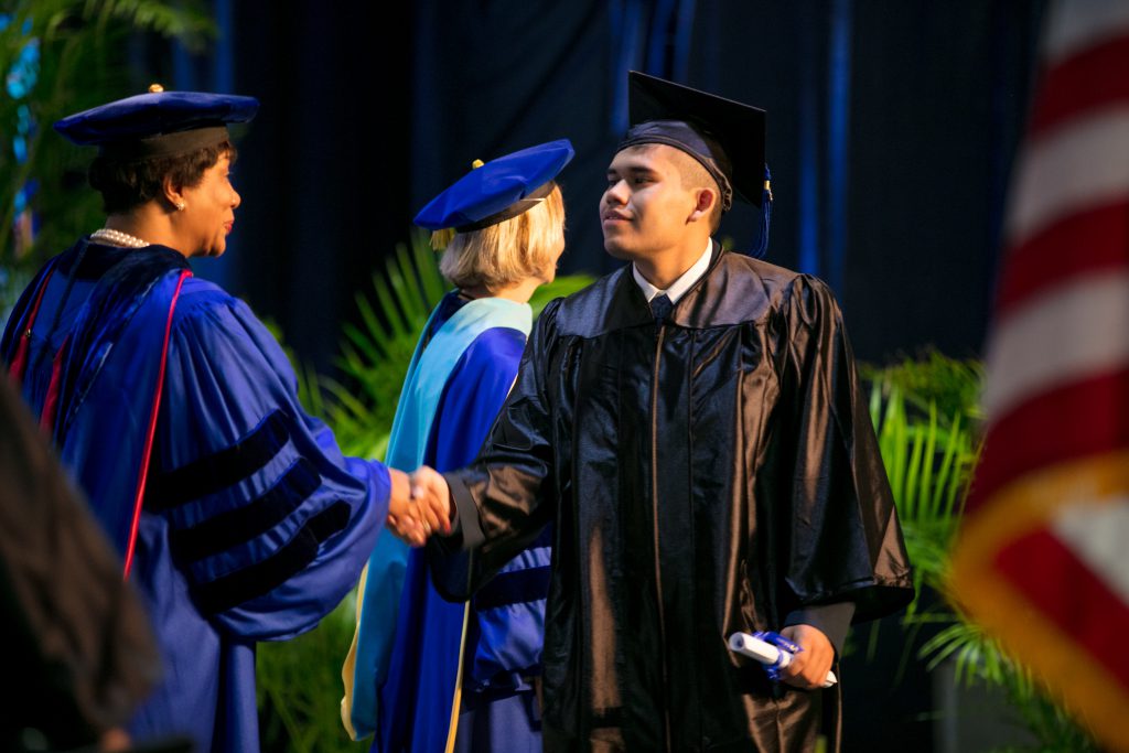 Student shaking Homestead president Jeanne F. Jacobs' hand.