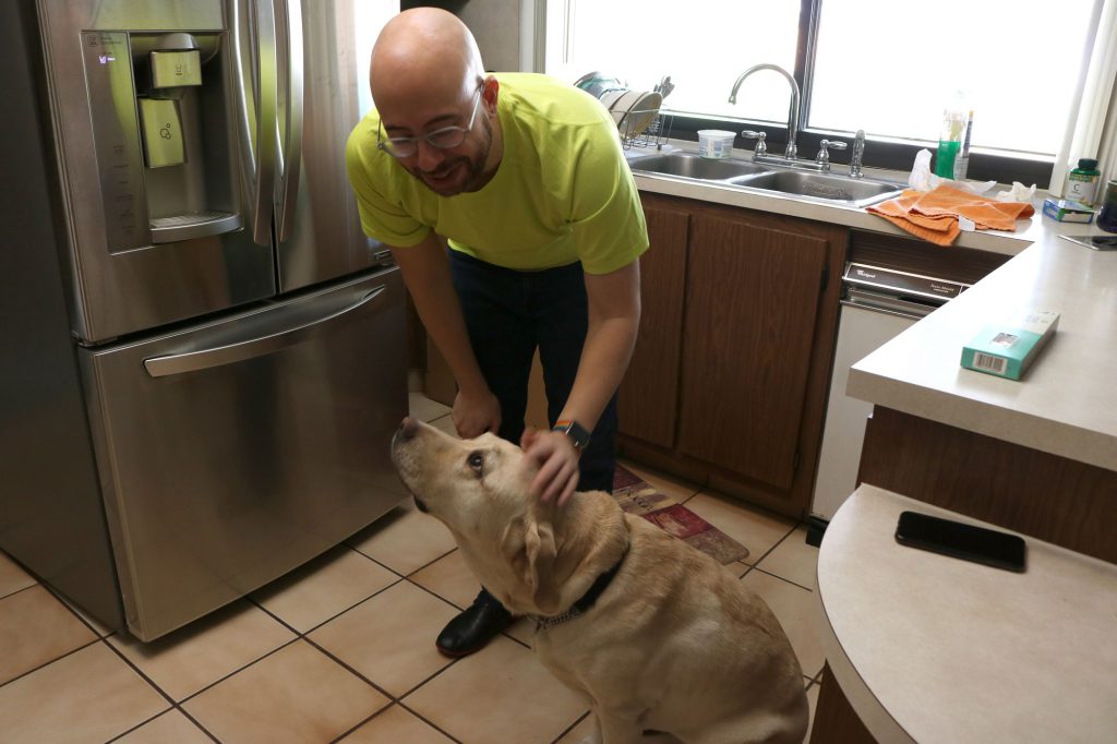 Gabriel with his guide dog Posh in the kitchen.