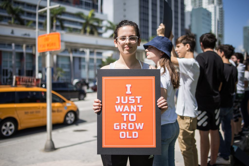 Young protestor holding sign.