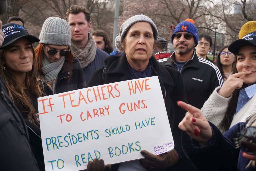 A teacher holding up her protest sign.