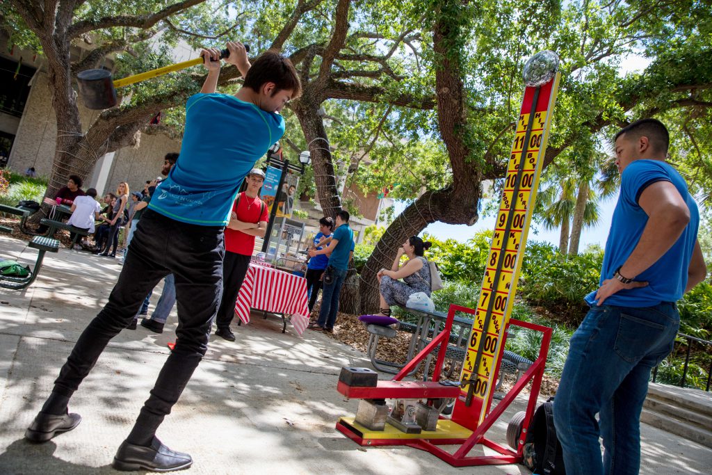 Student swinging a hammer at the high striker.