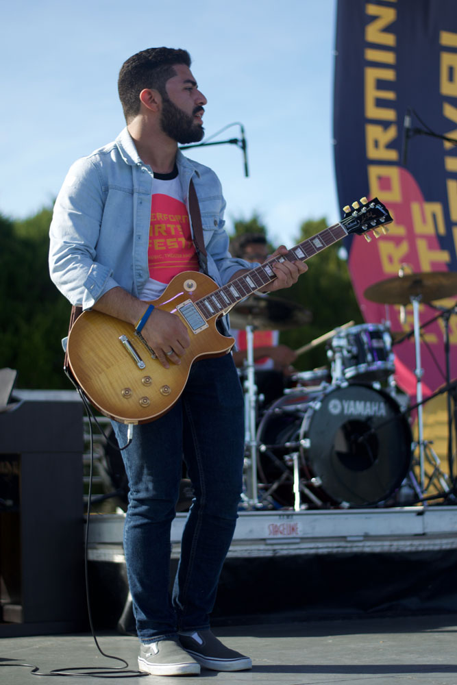Student Jonathan Diaz playing guitar on stage.