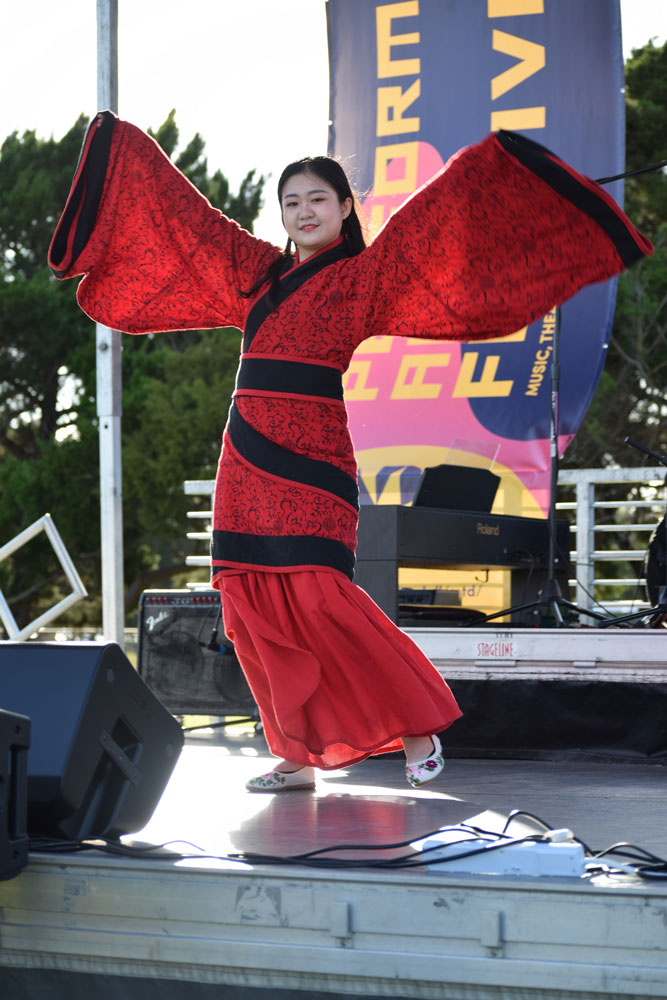Jue Chou performing a Chinese folk dance on stage.