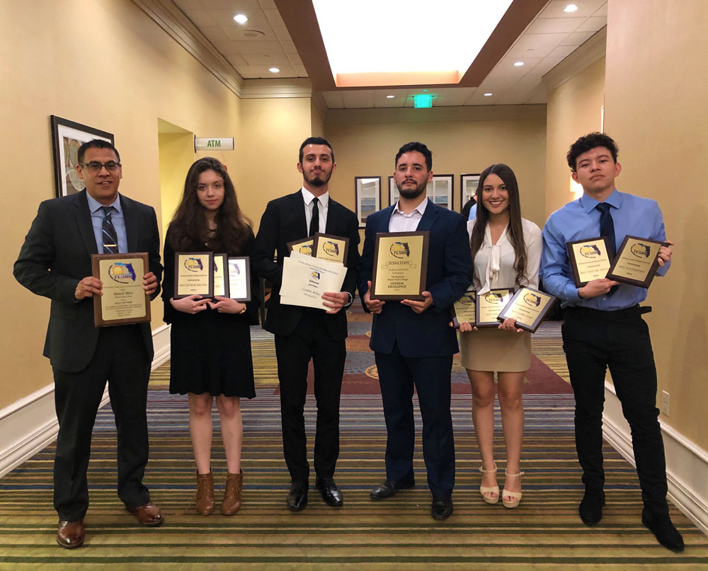 Students of The Reporter, along with their adviser, holding their Florida College Systems Publications Association awards.
