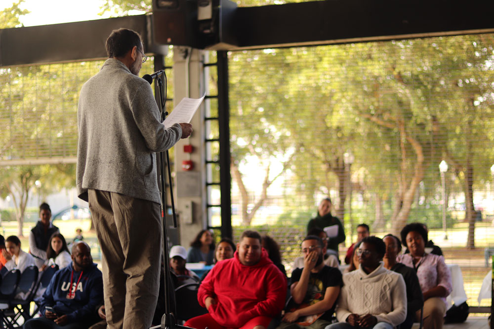 Librarian Steve Kronen reciting a poem on stage.
