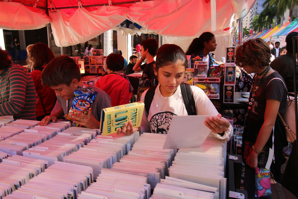 Kids looking through boxes of books.