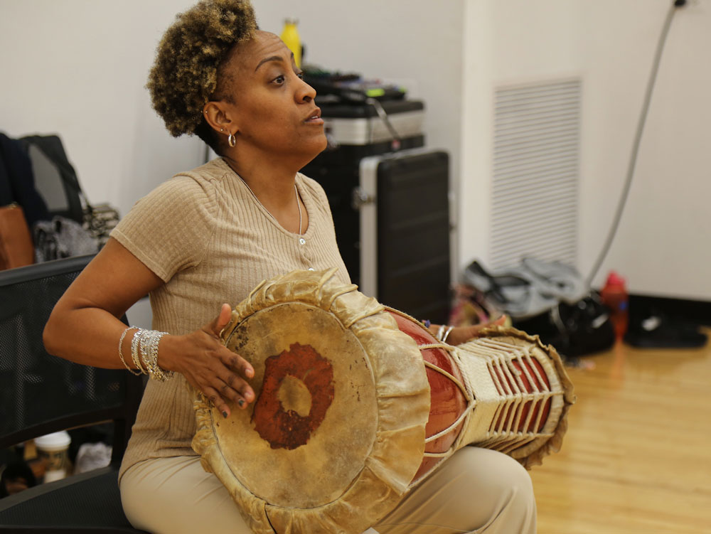 Marisol Blanco banging on a conga drum.